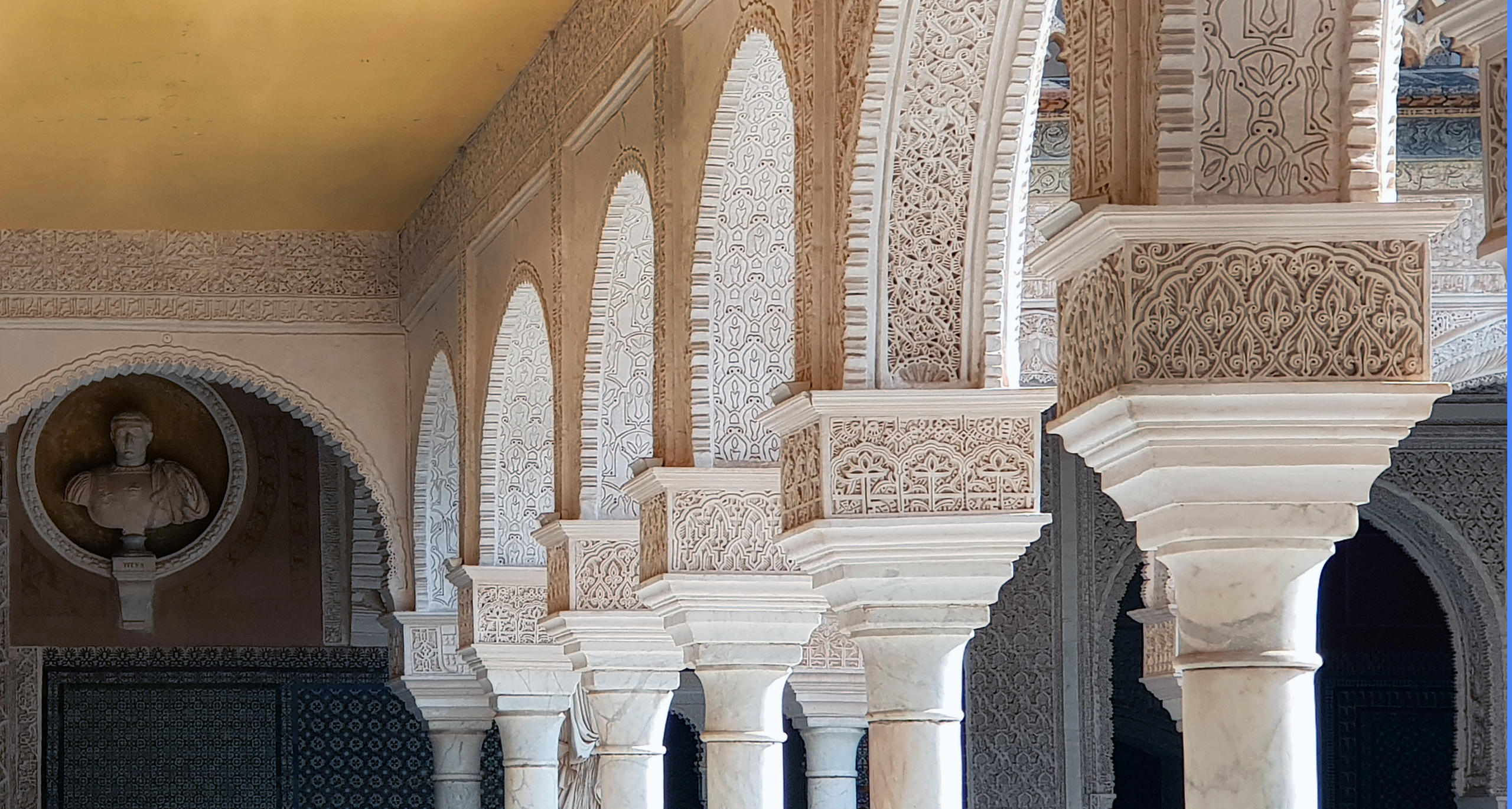 Ornate arches and columns in a historic building with intricate carvings.