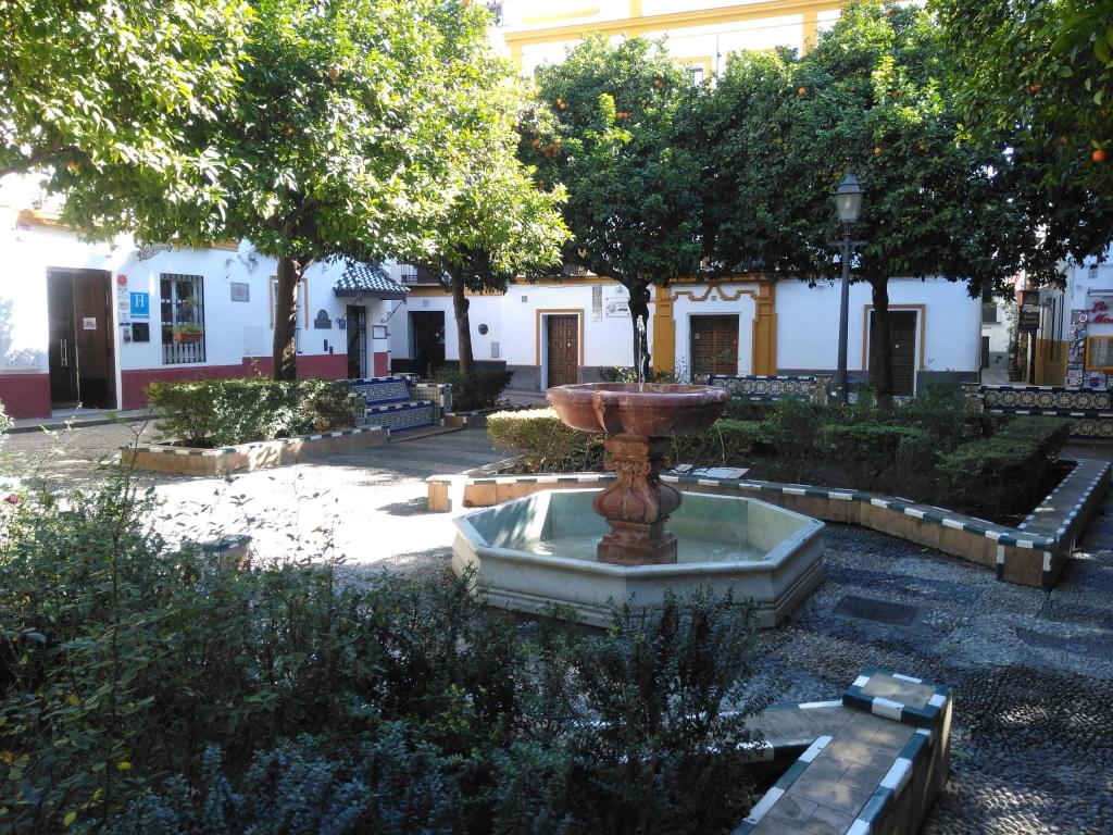 Peaceful courtyard with fountain, trees, and surrounding benches.