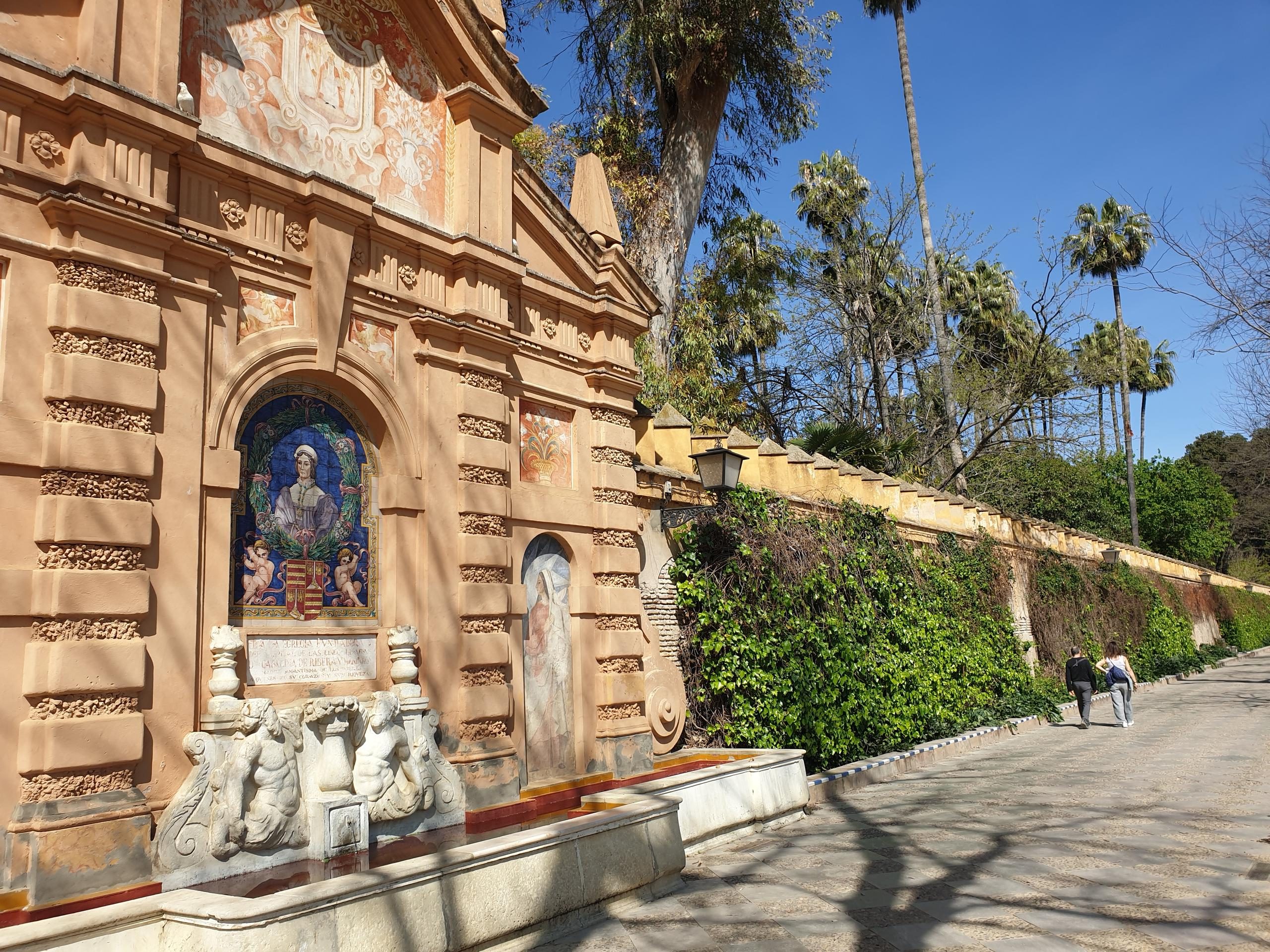 Upside-down view of a tan building with ornate details and greenery.