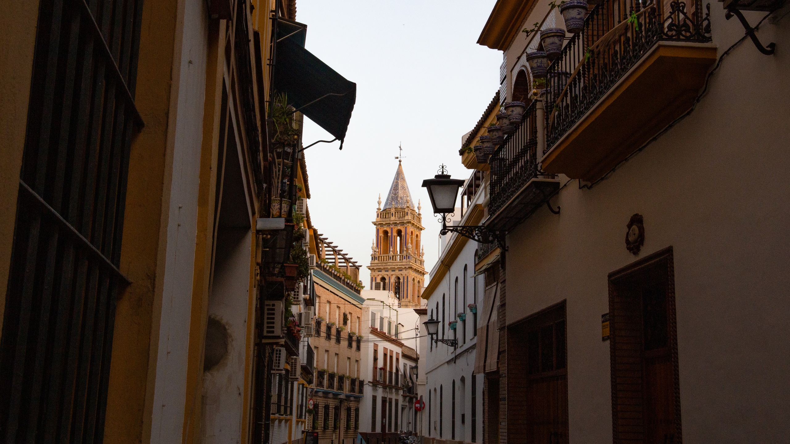Narrow street with historic buildings and distant church spire.