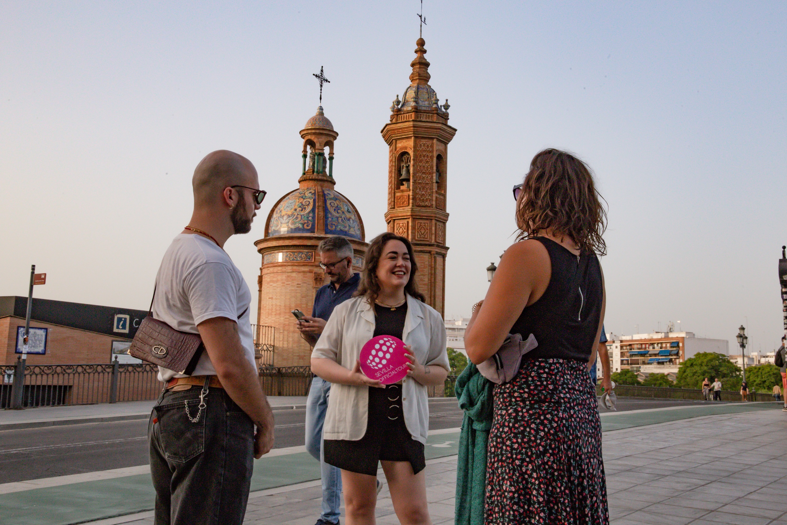 Group of people talking near a church with two bell towers.