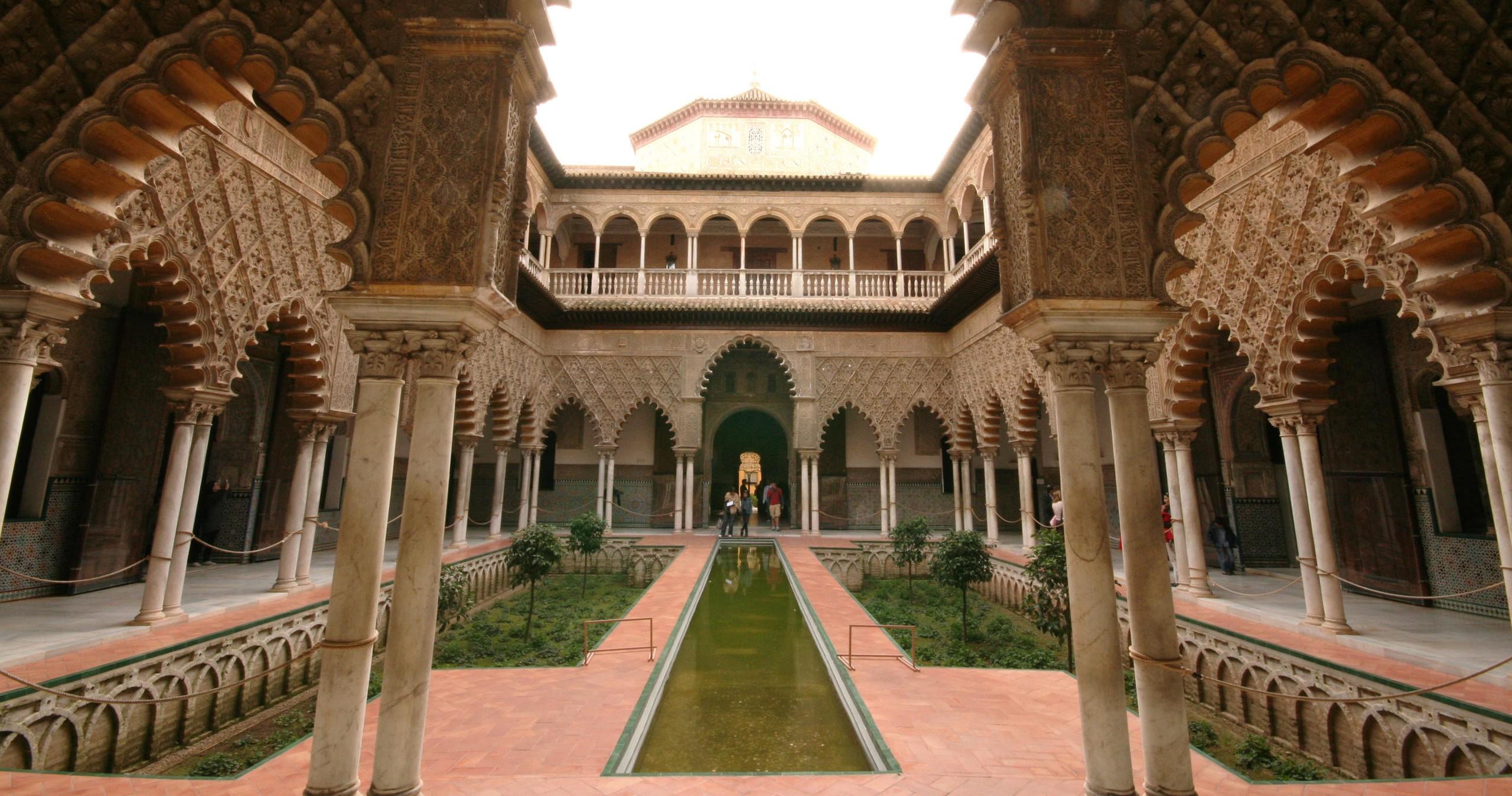Ornate courtyard with central reflecting pool, arched columns, and intricate detailing.